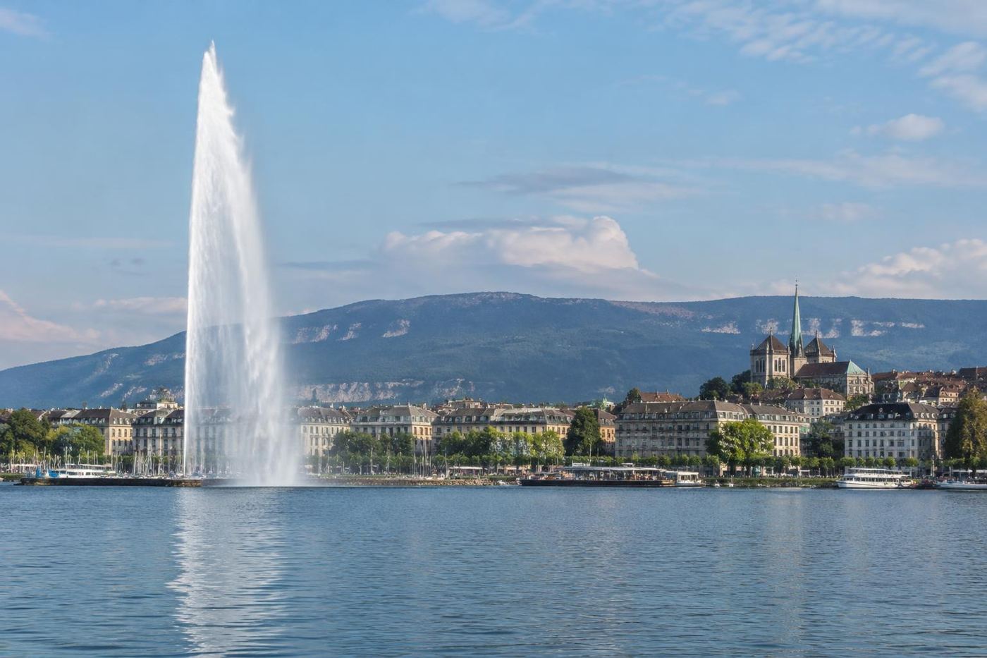 Jet d'Eau fountain on Lake Geneva with the city skyline