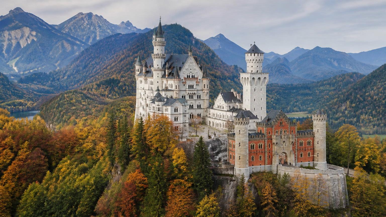 Neuschwanstein Castle in Bavaria surrounded by autumn forests and alpine mountains