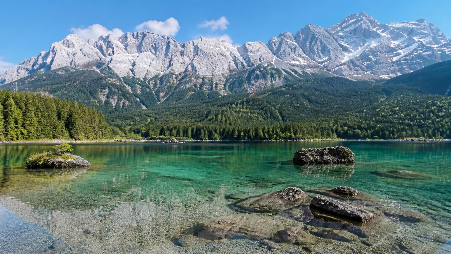 Turquoise Eibsee lake beneath the snow-capped Zugspitze massif in Bavaria, Germany